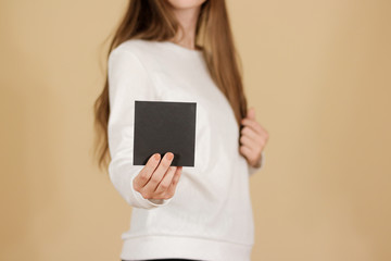 Girl showing blank black square flyer brochure booklet. Leaflet presentation. Pamphlet hold hands....