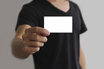 Man offering white card, isolated over grey background
