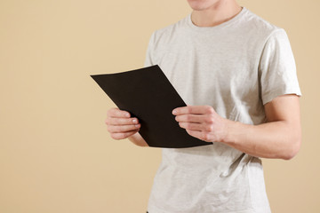 Man holding black A4 paper. Read booklet. Leaflet presentation. Pamphlet hold hands. Man show clear...