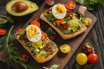 Bruschetta with avocado, egg and tomatoes.