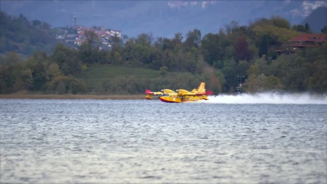 Pusiano, Italy - October 2017: Firefighting aircraft Canadair refilling from the lake during the fire emergency in the mountains near Como