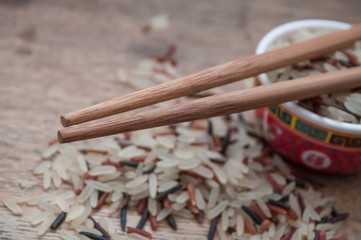 grains de riz et baguettes chinoise sur table en bois