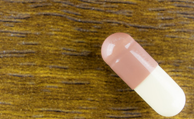 Medicine pills or capsules on wood background.Drug prescription for treatment medication.Pharmaceutical medicament,cure for health.Pharmacy theme, capsule pills with medicine antibiotic in packages.