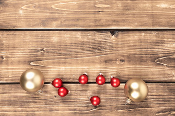 Naklejka na ściany i meble red and gold christmas balls on a wooden background