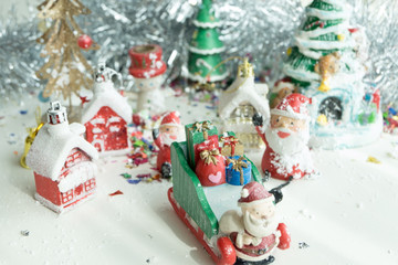 Cute happy Santa Claus dolls and Christmas props decorations on christmas snow field background