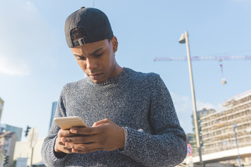 Young black man outdoor using smart phone - technology, social network, communication concept