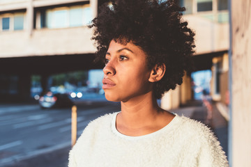 Portrait of young beautiful mixed race woman outdoor in the city looking sideway pensive - carefree, serene, thoughtless concept