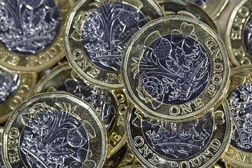 British Currency - pile of one pound coins in a horizontal format