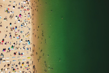 Fototapeta na wymiar Aerial Summer View Of People Crowd Having Fun On Cascais Beach In Portugal