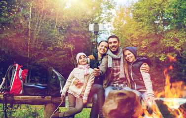 Fototapeta na wymiar family with smartphone taking selfie near campfire