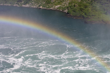 Rainbow over a river with waves