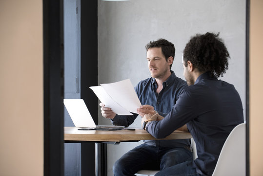 Men in office reviewing document