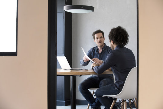 Men discussing contents of document