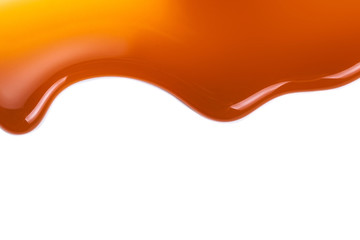 Sweet caramel sauce isolated on white background close up. Golden Butterscotch toffee caramel liquid .