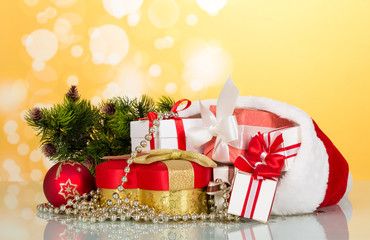 Large and small boxes in the header of Santa Claus, next to gift in heart shaped decorations for the Christmas tree, on yellow