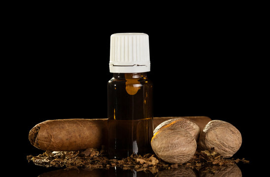 A bottle of liquid for Smoking, cigar and nutmeg isolated on black