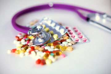 Stethoscope and some pills - isolated on a white background