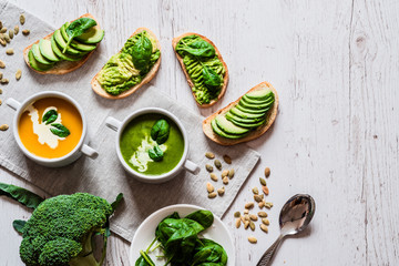 Vegetarian healthy food. Soup and vegan sandwiches. Different sandwiches with avocado. Brunch on white wooden background