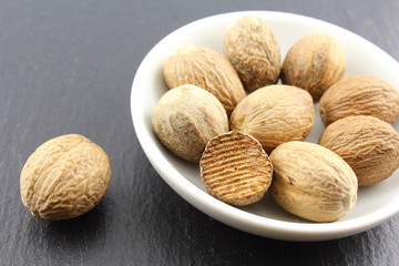 nutmeg seeds in a small white bowl