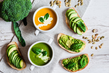 Vegetarian healthy food. Soup and vegan sandwiches. Different sandwiches with avocado. Brunch on white wooden background