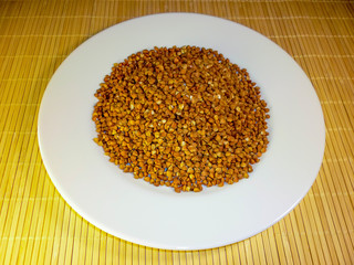buckwheat in a white plate on a light background