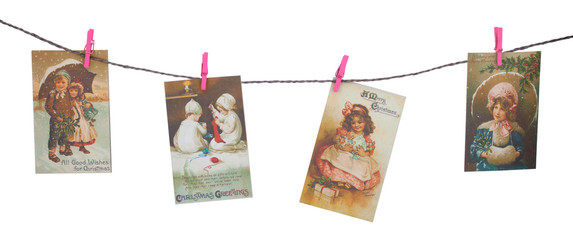 Retro Christmas cards hang on a rope with clothespins isolated on white background