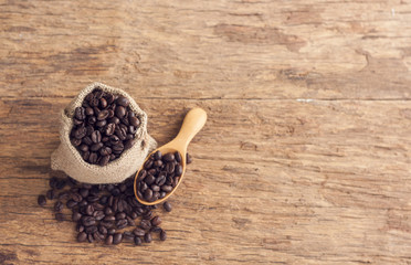 Coffee seeds in sack on top wooden table