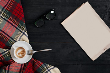 Workspace with newspaper, coffee cup, scarf, glasses. Stylish office desk. Autumn or Winter concept. Flat lay, top view