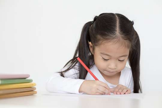 Attractive Little Girl writing Book. Dad Teaching her at home. Children Lifestyle, Education Concept.