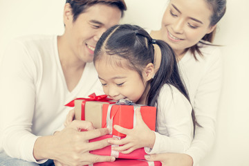 Attractive Asian family holding with each other. Kid received Gift with Attractive smiling. Kid with Happy Emotion. Vintage tone.