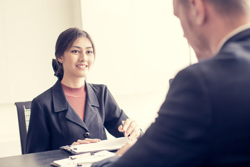 Asian Businesswoman working with businessman at office. Woman help Businessman for a Project. People working Concept. Vintage Tone. © Jestercine