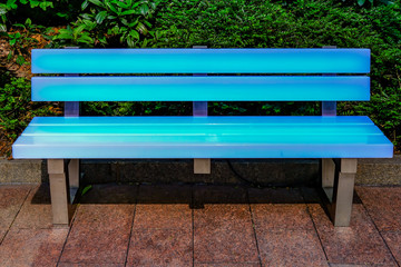 Blue illuminated bench with metal legs