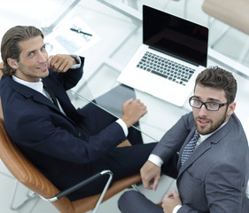 successful employees sitting behind a Desk