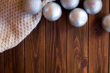 Christmas balls, toys on the Christmas tree silver on a brown wooden background
