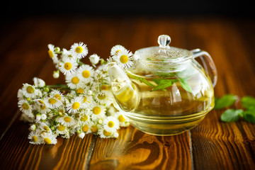 Glass teapot with chamomile tea
