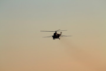 Helicopter flying in the blue evening sky