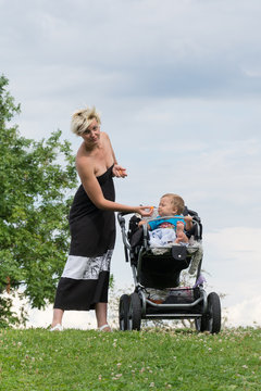 Mom and her son in baby carriages on the grass