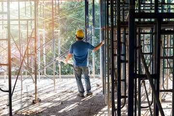 Engineer with blueprint in building construction site