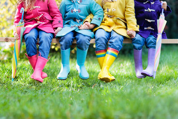 Kids in rain boots. Foot wear for children.
