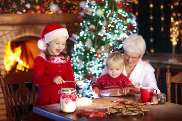 Grandmother and kids bake Christmas cookies.