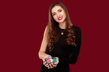 Casino, gambling, poker, people and entertainment concept - woman poker player in black dress with...