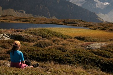 Naklejka na ściany i meble girl watching beautiful mountain landscape Pass S.Bernardino Switzerland