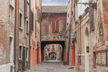 Fototapeta na wymiar Old narrow medieval street of the center of Ferrara