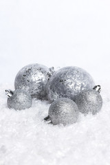 Christmas tree ornaments positioned in a snow setting with white background