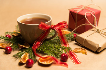 Cup of black tea, Christmas toys, gifts and decorations on craft background