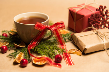 Fototapeta na wymiar Cup of black tea, Christmas toys, gifts and decorations on craft background