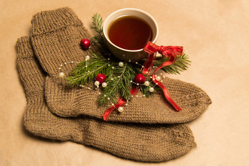 Cup of black tea, Christmas toys, gifts and decorations on craft background