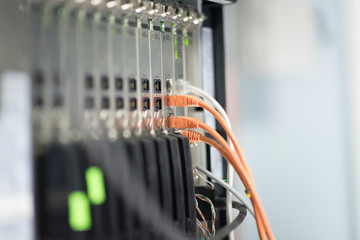 Network panel, switch and orange cable in data center