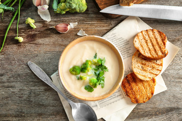 Bowl of yummy potato soup with croutons on wooden table