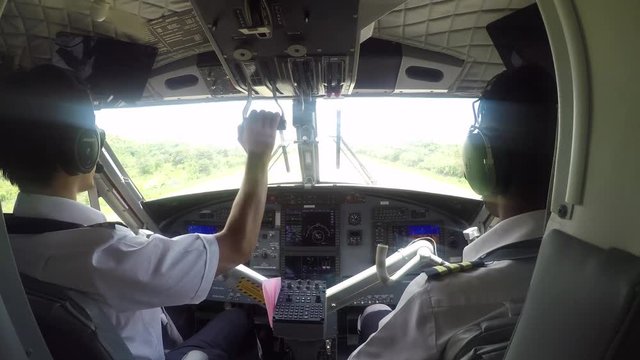 GoPro point of view into the cockpit of a small plane with two pilots ready for landing on a tropical island Praslin, Seychelles POV.  